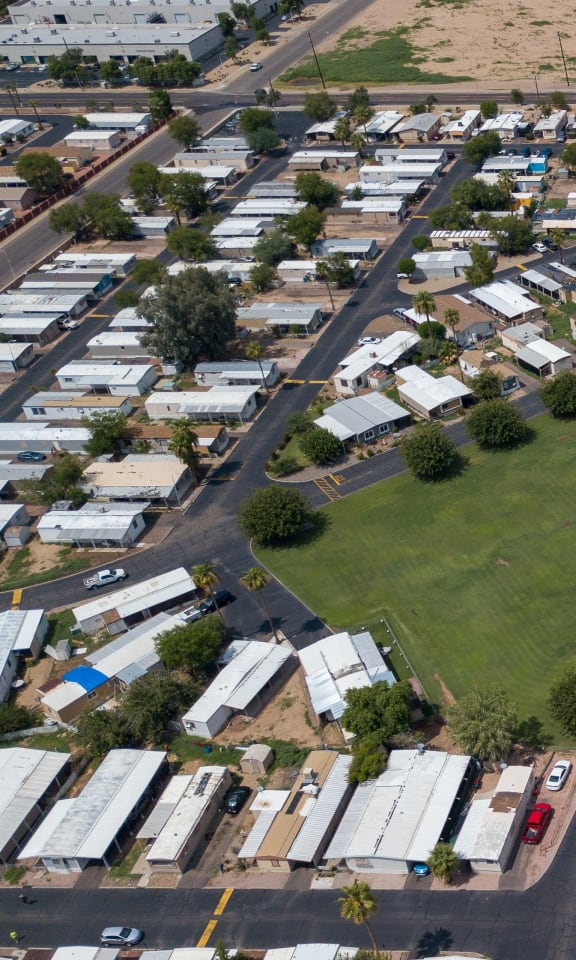 Bird's eye view of Belaire Manor, showing the large grass field, basketball court, playground equipment, and pool.