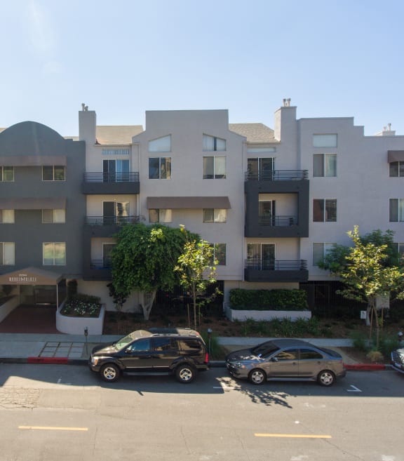 an apartment building with cars parked in front of it