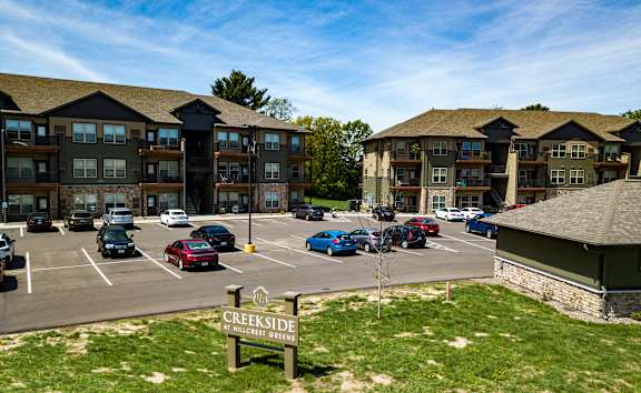 A parking lot with cars and a sign that says Creekside.