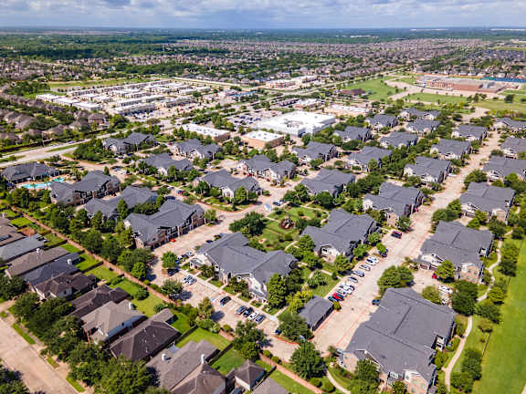 A suburban neighborhood with houses and a parking lot at Avenues at Shadow Creek Ranch Apartments, Pearland