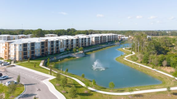 an aerial view of lakeside village with a fountain in the middle of the lake