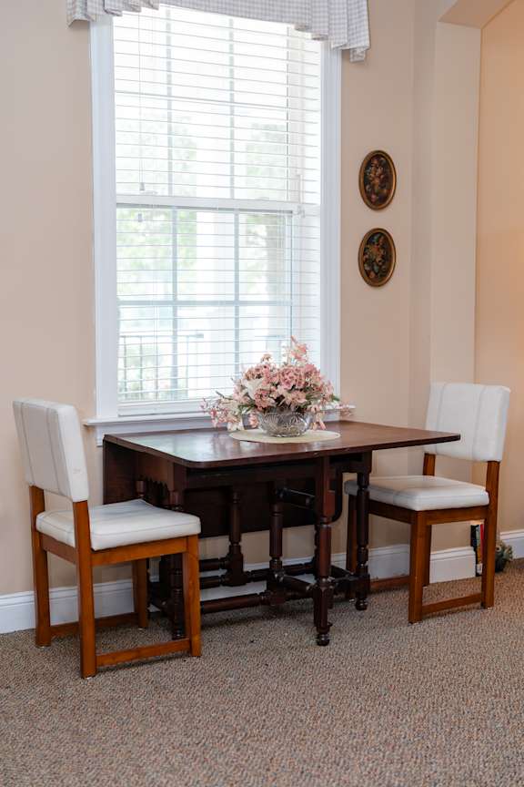A dining room with a table and chairs.