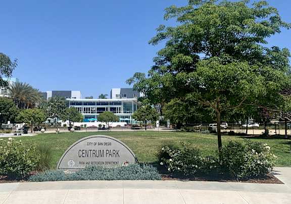 a park with trees and a sign for the entrance park