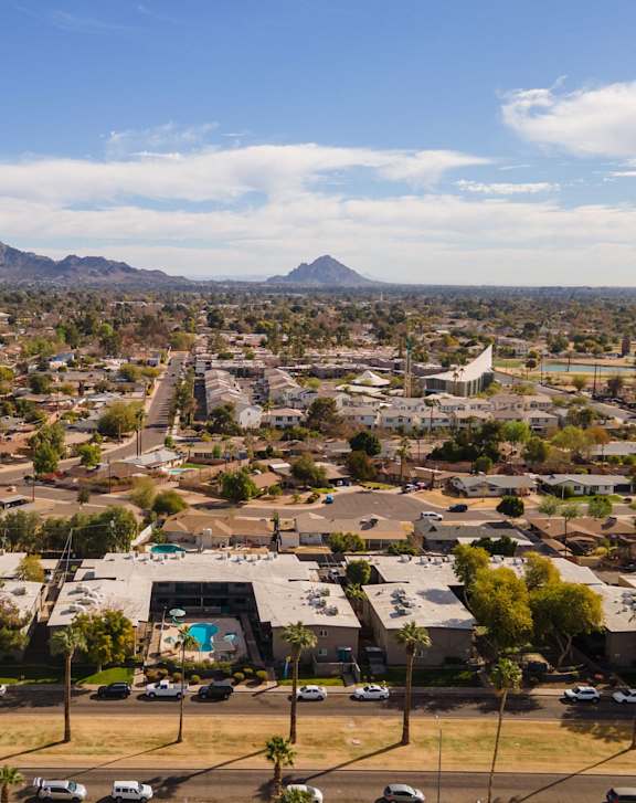 A cityscape with a clear blue sky and a mountain in the distance.