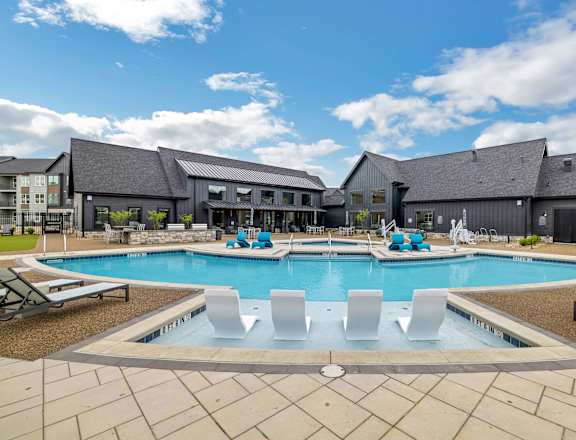 a swimming pool with chairs around it in front of a building at Prism at Diamond Ridge, Moon Township, PA, 15108