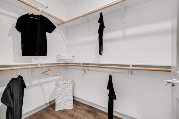 a white room with clothes hanging on a rack and a basket on the floor at Prism at Diamond Ridge, Moon Township, PA, 15108