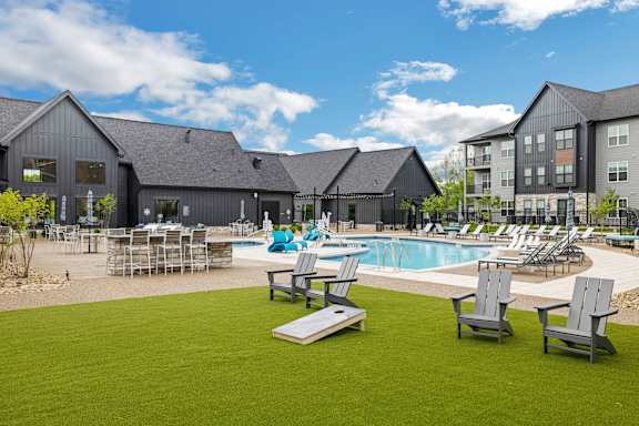 a swimming pool with lounge chairs in front of a building at Prism at Diamond Ridge, Moon Township, PA, 15108