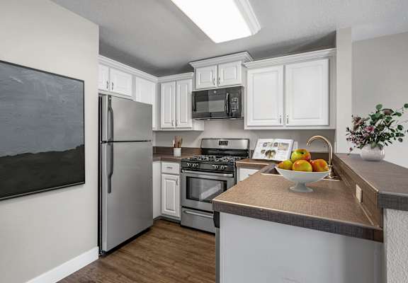 A kitchen with a refrigerator, oven, and microwave.