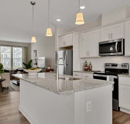 an open kitchen and living room with white cabinets and granite counter tops at Brandywine Crossing, Brandywine, MD 20613