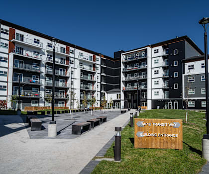 A building entrance sign is in front of a building.