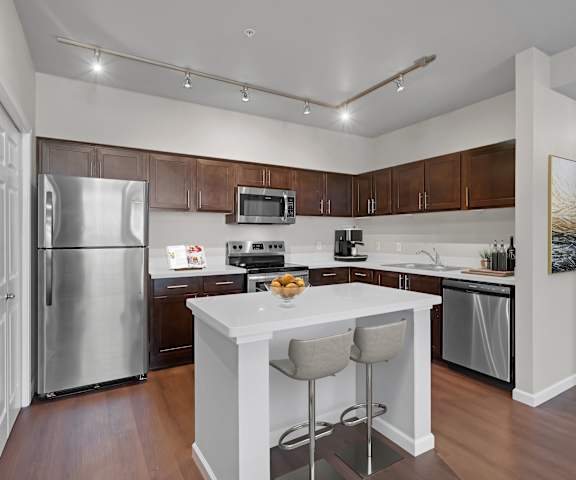 A kitchen with a white island and stainless steel appliances.