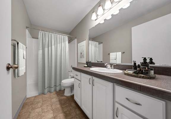 A bathroom with a white toilet and a white shower curtain.