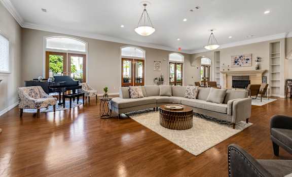 a living room with couches and chairs and a piano
