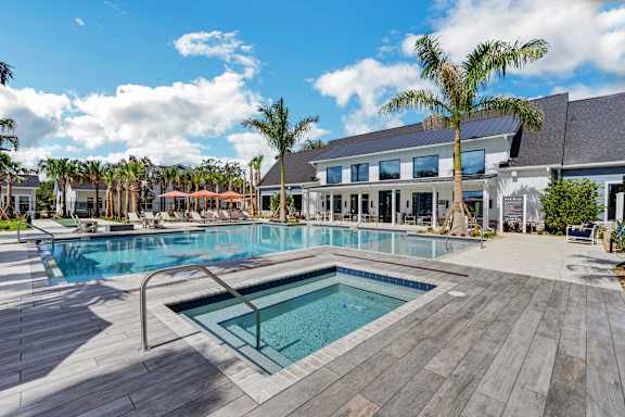 a swimming pool with palm trees and a building in the background at The Sophia, Florida