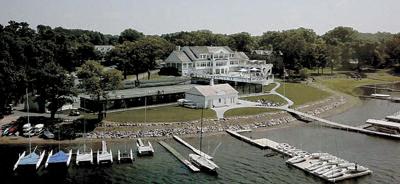 A large white house is surrounded by a dock and boats at The Barnum Apartments, MN, 55110