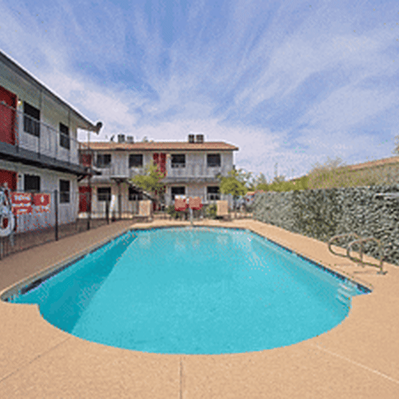A swimming pool in a courtyard surrounded by buildings.