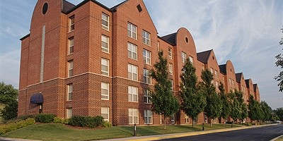 A long brick building with trees in front.