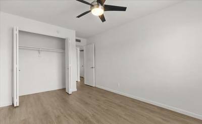 an empty bedroom with a ceiling fan and a closet