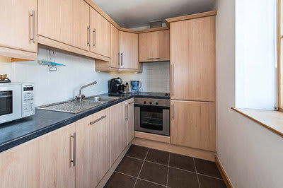 a kitchen with wooden cabinets and a microwave and a sink
