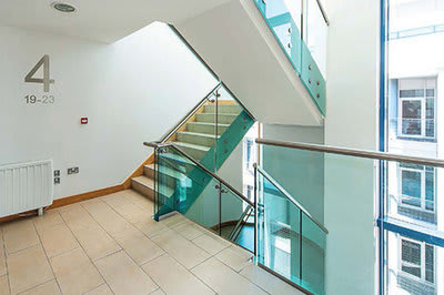 a glass staircase in a building with a glass railing