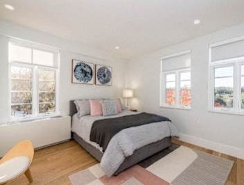 a bedroom with a bed and three windows