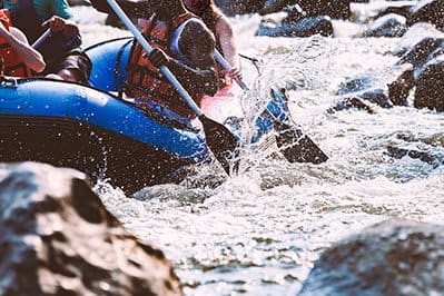 a group of people in a blue raft in the water