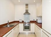 Thumbnail 3 of 3 - a kitchen with white cabinets and a stove and a sink
