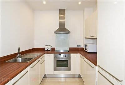 a kitchen with white cabinets and a stove and a sink