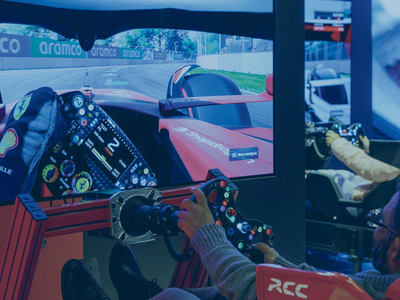 A person is playing a racing video game on a large screen.