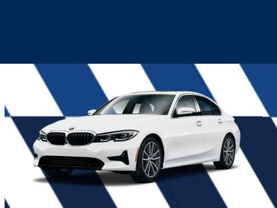 A white BMW car is positioned in front of a blue and white striped background.