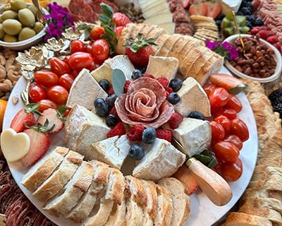 a platter of food with berries and cheese on a table
