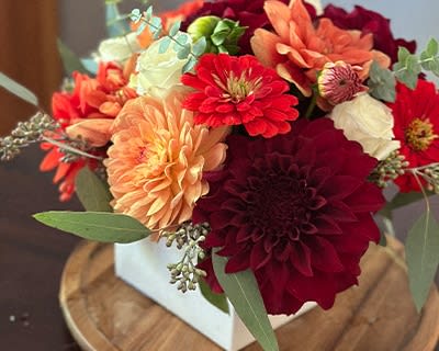a vase filled with red and orange flowers on a table
