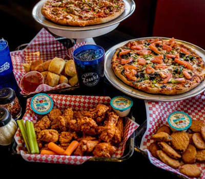 a table topped with pizzas and other food at Chandler Heights, Chandler, AZ
