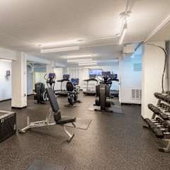 A gym with a variety of equipment including weights and cardio machines.