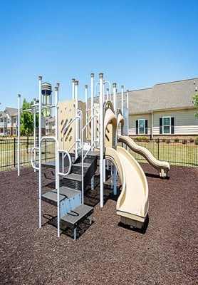 A playground with a slide and climbing structure.