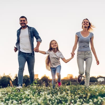 a happy family walking through a field of flowers