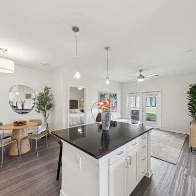 a kitchen with a large island and a living room with a table and chairs