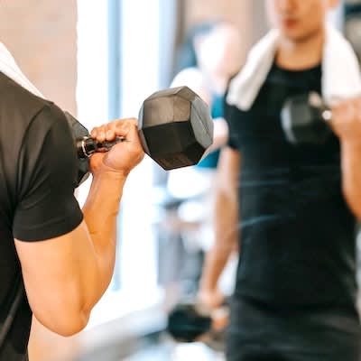 a man lifting a dumbbell in a gym