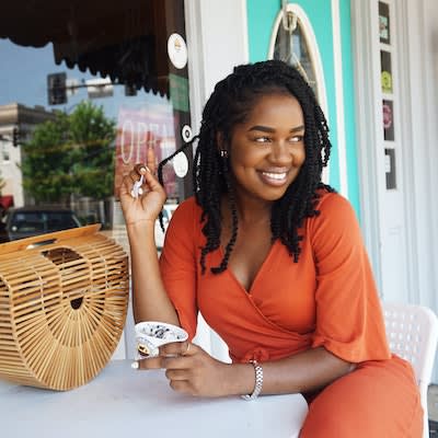 a woman sitting at a table with a cup of coffee