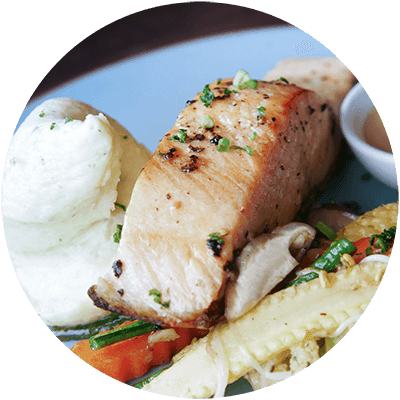 A plate of food with a piece of meat, mashed potatoes, and vegetables.