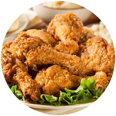 A plate of fried chicken wings and two red chili peppers.