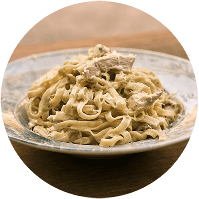 A plate of pasta with chicken on top.