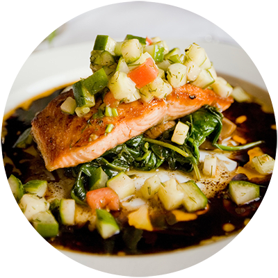 a bowl of food with salmon and vegetables