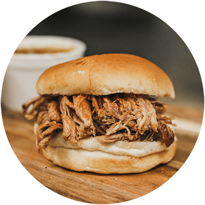 a pulled pork sandwich on a wooden cutting board