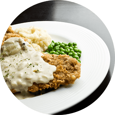 A plate of food with a piece of meat and vegetables.
