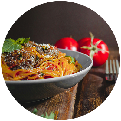A bowl of spaghetti with meatballs and tomato sauce.