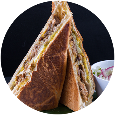 a sandwich cut in half next to a bowl of salad