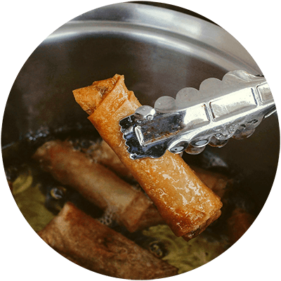 a knife cutting into a piece of cinnamon stick in a pan