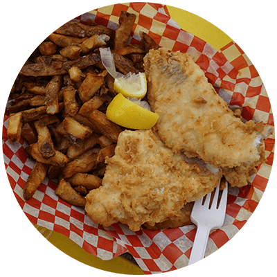 a plate of fried fish and potatoes with a fork