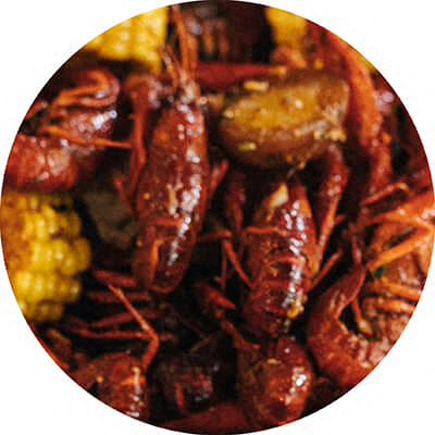 A plate of cooked crawfish and corn on the cob.